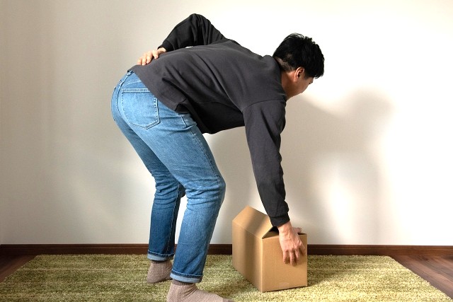 腰に痛みの走る男性