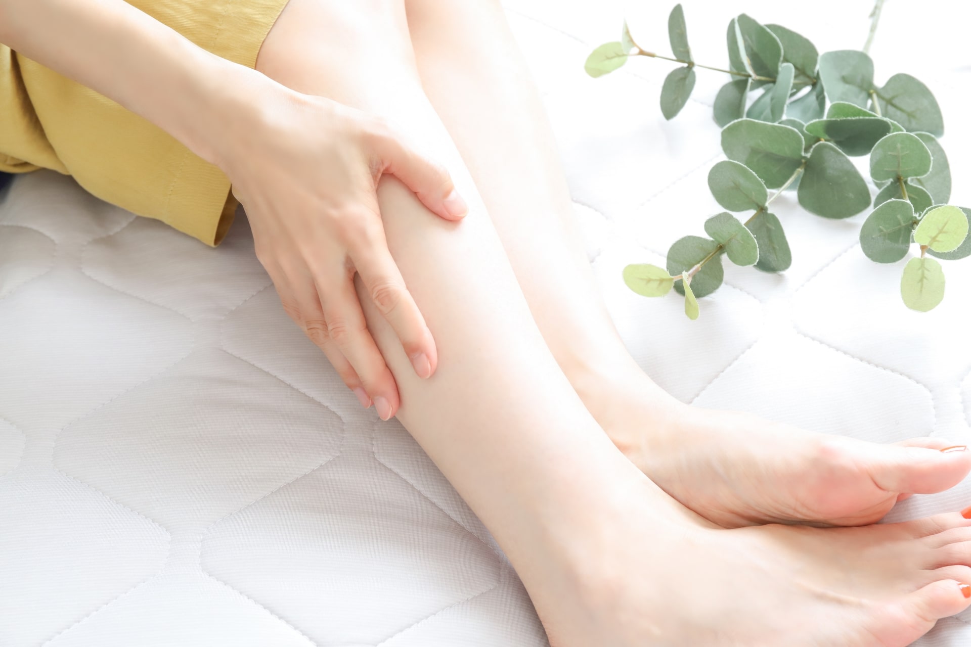 ふくらはぎに手を当てる女性